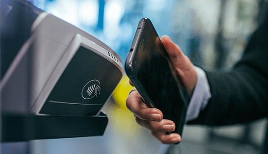 automation in banking: user holds cell phone near reader