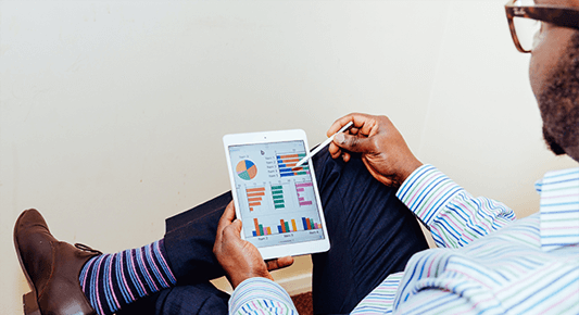 financial process automation: man looking at data charts on a tablet